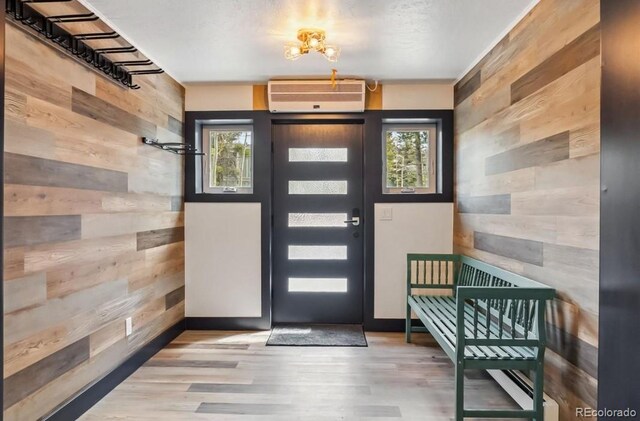 142 High Point Dr, Breckenridge, CO 80424 - foyer entrance featuring a wall mounted air conditioner, wooden walls, and wood finished floors