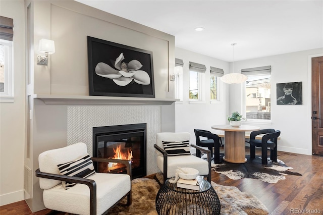 interior space with a tile fireplace and hardwood / wood-style floors