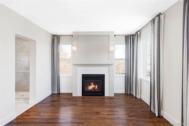 unfurnished living room with dark hardwood / wood-style floors and a wealth of natural light