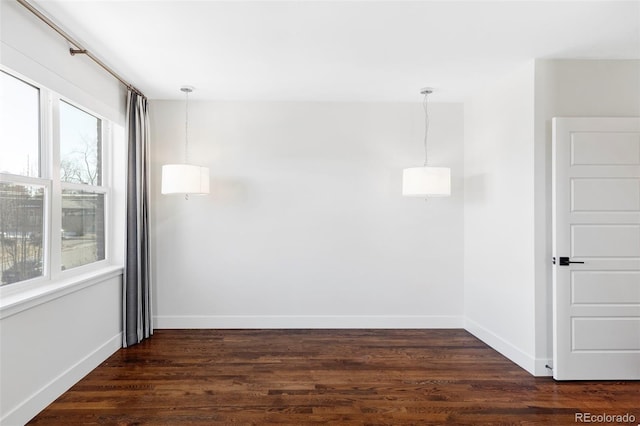 spare room with plenty of natural light and dark hardwood / wood-style flooring