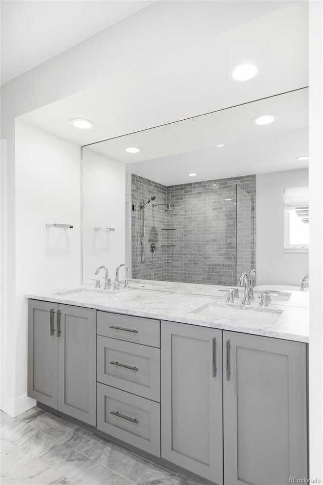 bathroom featuring a tile shower and vanity