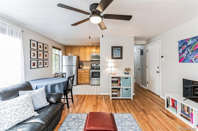 living room featuring ceiling fan and light wood-type flooring