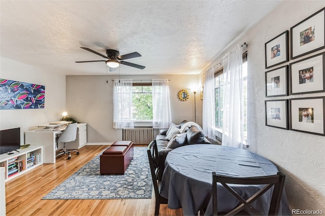 interior space with hardwood / wood-style floors, ceiling fan, radiator heating unit, and a textured ceiling