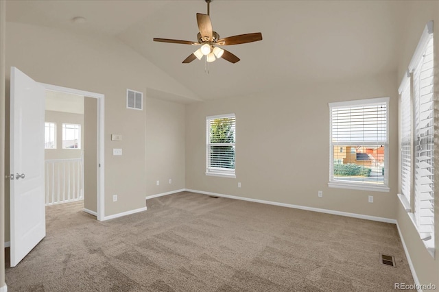 carpeted spare room featuring vaulted ceiling, ceiling fan, and a healthy amount of sunlight