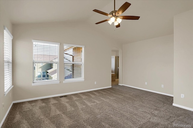 carpeted spare room with ceiling fan and vaulted ceiling