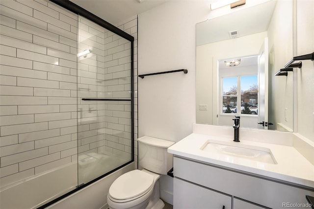 full bathroom featuring a chandelier, vanity, combined bath / shower with glass door, and toilet