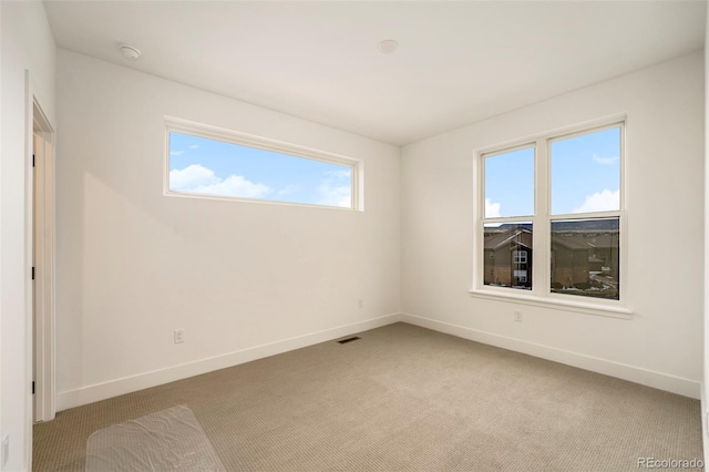 spare room featuring light carpet