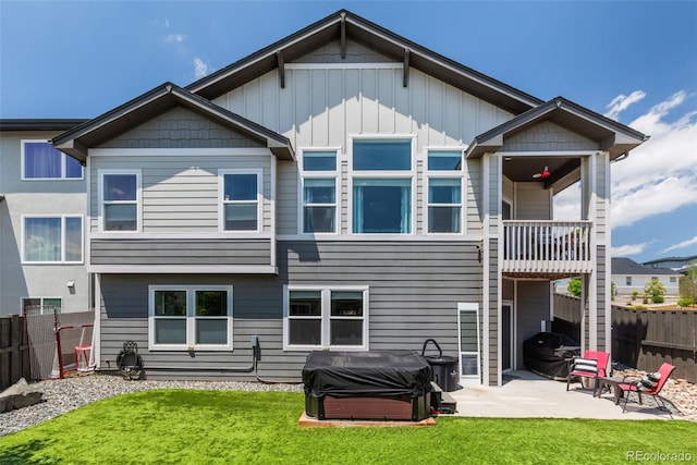 1177 Man O War Way, Colorado Springs, CO 80921 - rear view of property featuring a hot tub, a balcony, a fenced backyard, a patio area, and board and batten siding
