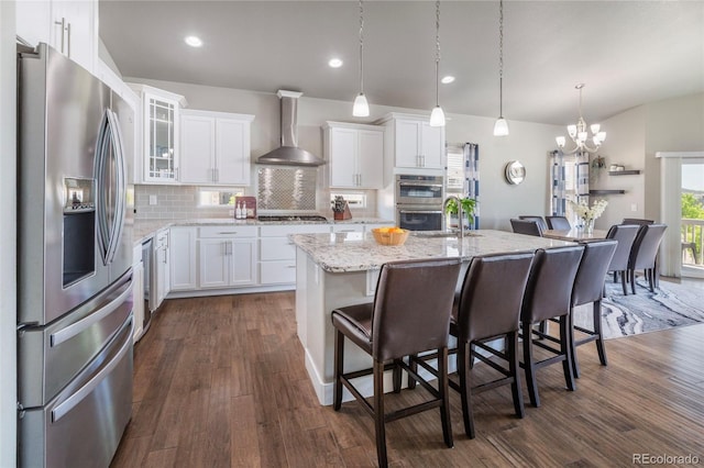 1177 Man O War Way, Colorado Springs, CO 80921 - kitchen featuring stainless steel appliances, wall chimney exhaust hood, a chandelier, backsplash, and white cabinets