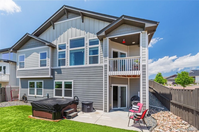 1177 Man O War Way, Colorado Springs, CO 80921 - back of house featuring a hot tub, a balcony, a fenced backyard, a patio, and board and batten siding