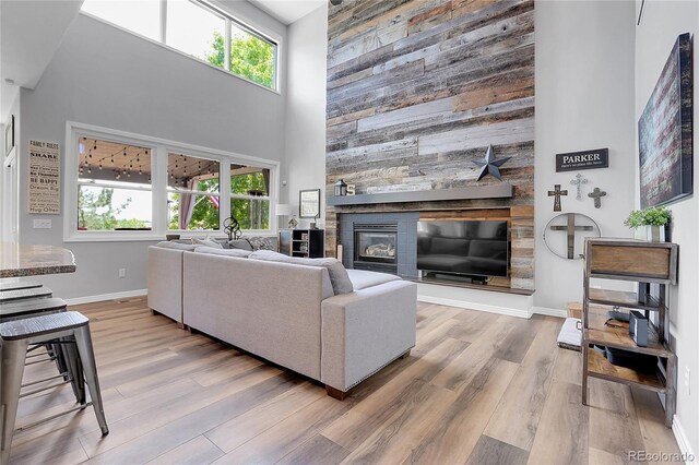 10822 Eagle Crest Ct, Parker, CO 80138 - living room featuring a high ceiling, wood finished floors, plenty of natural light, a stone fireplace, and wooden walls
