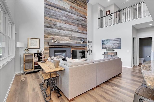10822 Eagle Crest Ct, Parker, CO 80138 - living room with a towering ceiling, wood finished floors, a fireplace, wood walls, and recessed lighting