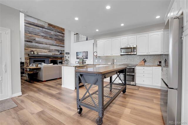 10822 Eagle Crest Ct, Parker, CO 80138 - kitchen with appliances with stainless steel finishes, a peninsula, white cabinets, recessed lighting, and wooden walls