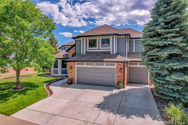 10822 Eagle Crest Ct, Parker, CO 80138 - view of front of property with a garage, driveway, a front lawn, and brick siding