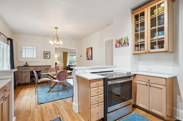 1870 S Ogden St, Denver, CO 80210 - kitchen with electric range, light wood-style floors, a peninsula, a chandelier, and light countertops