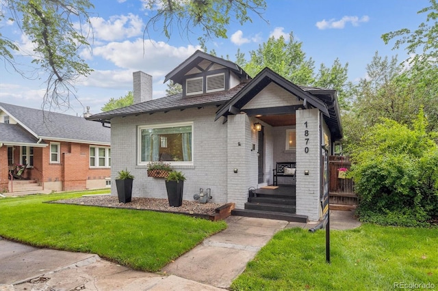 1870 S Ogden St, Denver, CO 80210 - view of front of house with a chimney, a front lawn, and brick siding