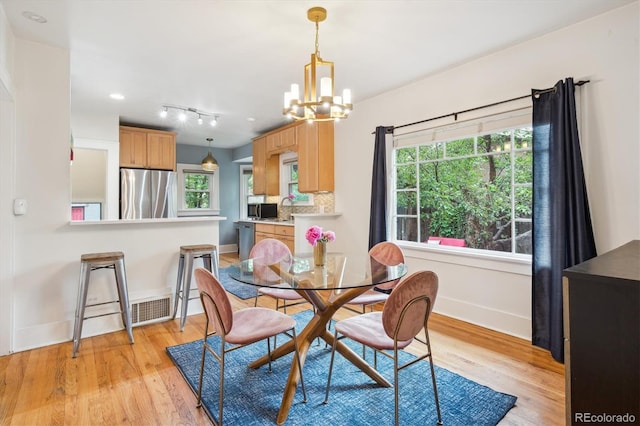 1870 S Ogden St, Denver, CO 80210 - dining space with baseboards, light wood-type flooring, a chandelier, and plenty of natural light