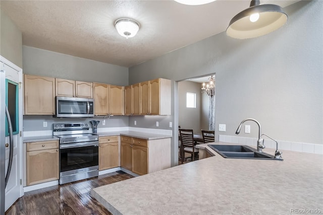 13152 E 104th Dr, Commerce City, CO 80022 - kitchen with appliances with stainless steel finishes, light brown cabinetry, dark wood finished floors, and a textured ceiling