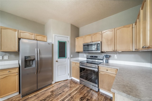 13152 E 104th Dr, Commerce City, CO 80022 - kitchen featuring appliances with stainless steel finishes, light brown cabinetry, dark wood-style floors, light countertops, and a textured ceiling