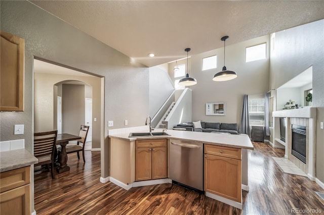 13152 E 104th Dr, Commerce City, CO 80022 - kitchen featuring stainless steel dishwasher, open floor plan, dark wood-style floors, a peninsula, and arched walkways