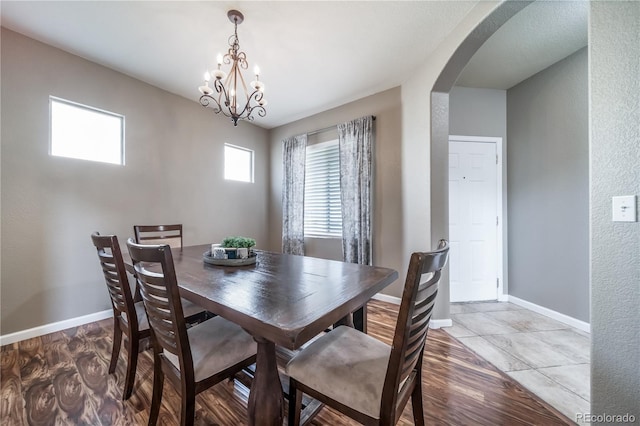 13152 E 104th Dr, Commerce City, CO 80022 - dining room with arched walkways, light wood finished floors, and a chandelier