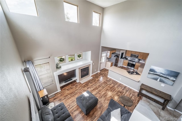 13152 E 104th Dr, Commerce City, CO 80022 - living room with a high ceiling, wood finished floors, and a tiled fireplace
