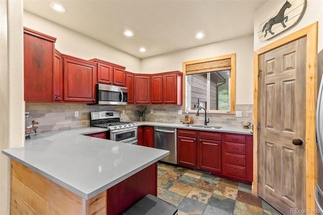 15608 Ouray Rd, Pine, CO 80470 - kitchen with stainless steel appliances, reddish brown cabinets, backsplash, a peninsula, and recessed lighting