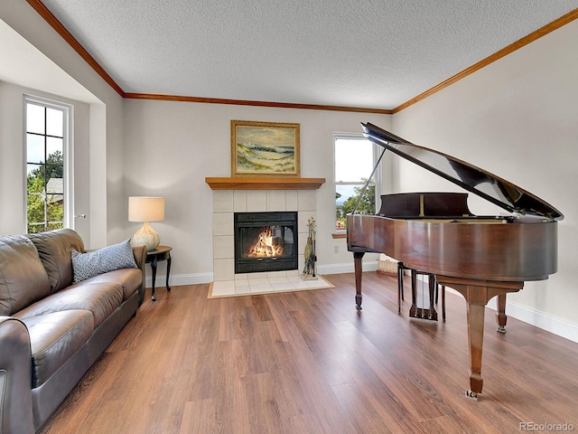 2145 Wynterbrook Dr, Highlands Ranch, CO 80126 - living area featuring ornamental molding, wood finished floors, a textured ceiling, and a tiled fireplace