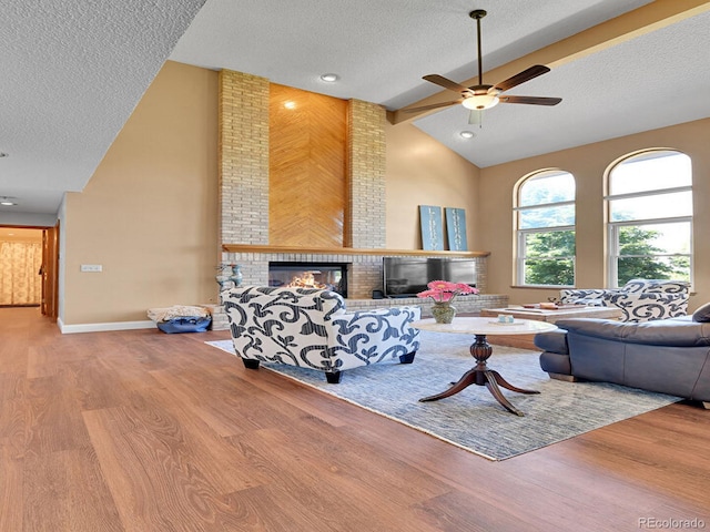 2145 Wynterbrook Dr, Highlands Ranch, CO 80126 - living area featuring a textured ceiling, wood finished floors, ceiling fan, a fireplace, and high vaulted ceiling
