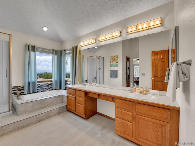 2145 Wynterbrook Dr, Highlands Ranch, CO 80126 - bathroom featuring double vanity, a textured ceiling, a garden tub, a shower with shower door, and recessed lighting