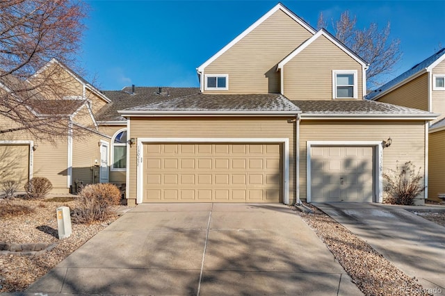 traditional-style house with driveway and a shingled roof