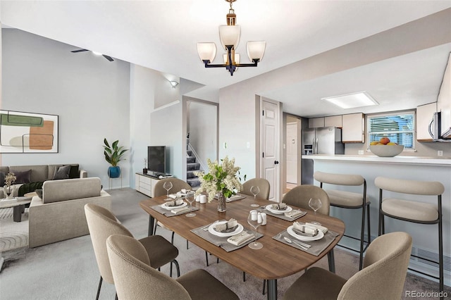 dining space featuring an inviting chandelier and stairway