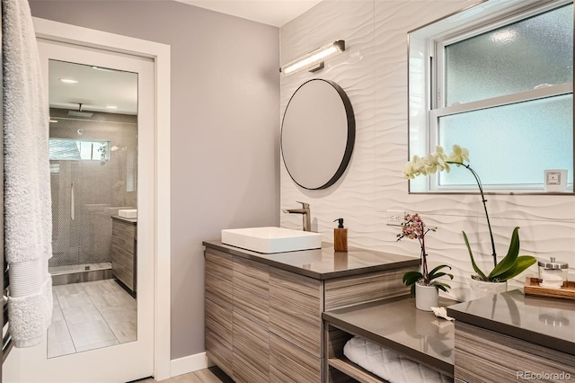 bathroom with vanity and a tile shower