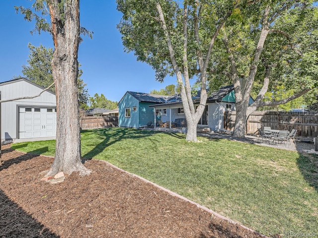 view of front of house with a front yard, an outdoor structure, and a garage