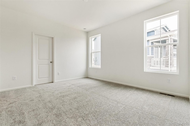 spare room featuring carpet flooring and baseboards