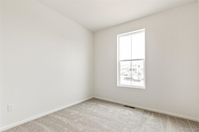 unfurnished room featuring baseboards and light colored carpet
