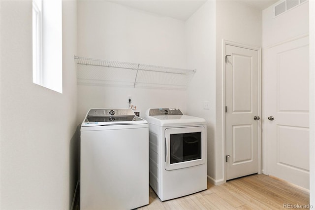 washroom featuring washer and clothes dryer and light wood-style flooring