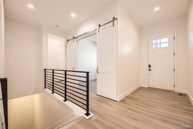 foyer featuring a barn door and light hardwood / wood-style floors