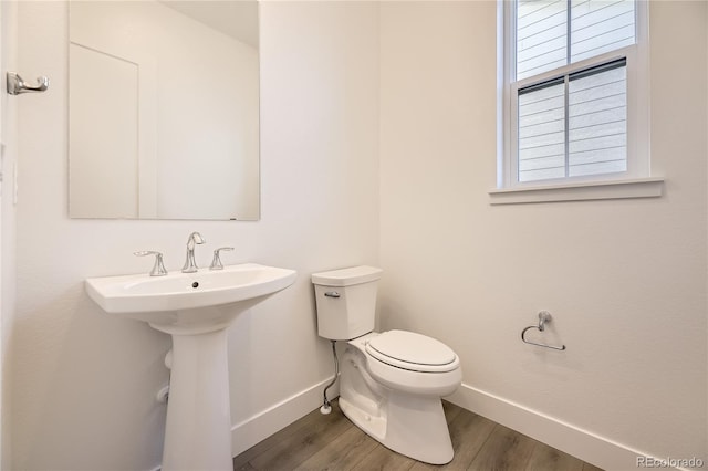 bathroom featuring wood-type flooring and toilet