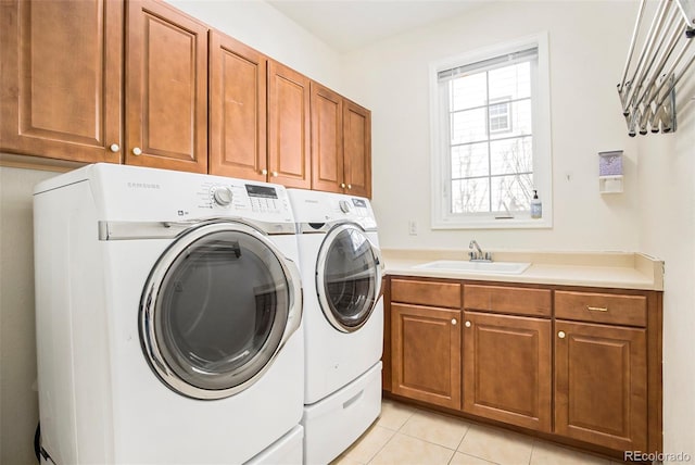 washroom with washer and dryer, cabinet space, a sink, and light tile patterned floors