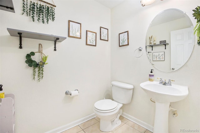 bathroom with baseboards, toilet, and tile patterned floors