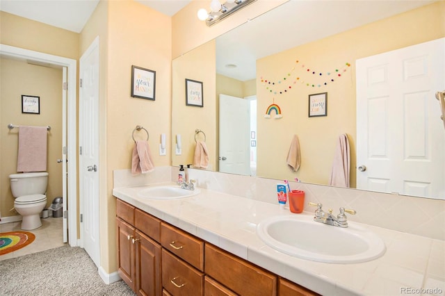 full bathroom featuring double vanity, tile patterned flooring, a sink, and toilet