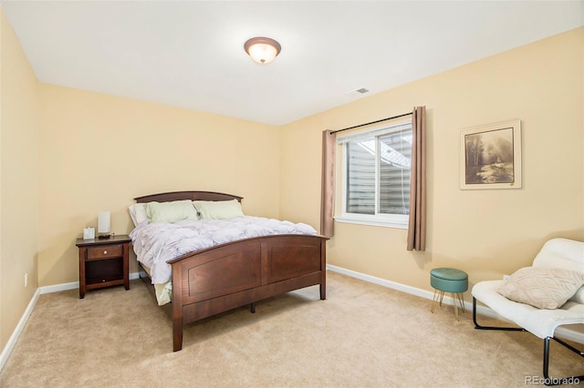 bedroom with baseboards and light colored carpet