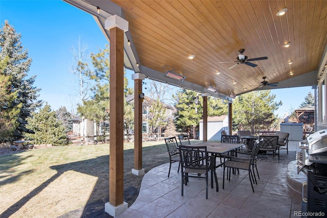 view of patio with a storage shed, outdoor dining area, an outdoor structure, and a ceiling fan