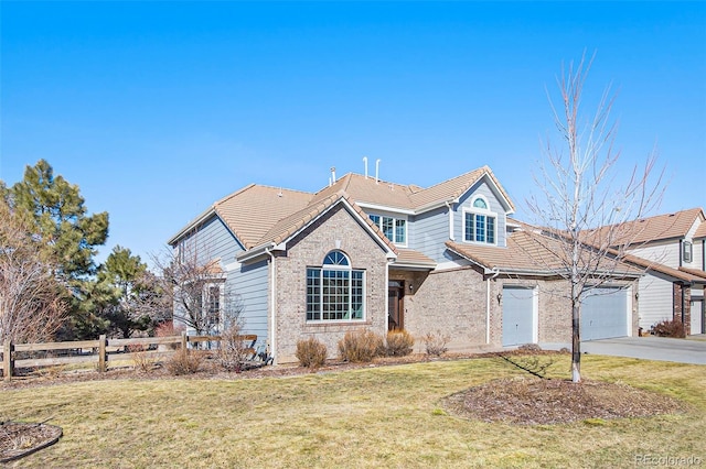 view of front of house featuring concrete driveway, a tiled roof, fence, a front yard, and brick siding