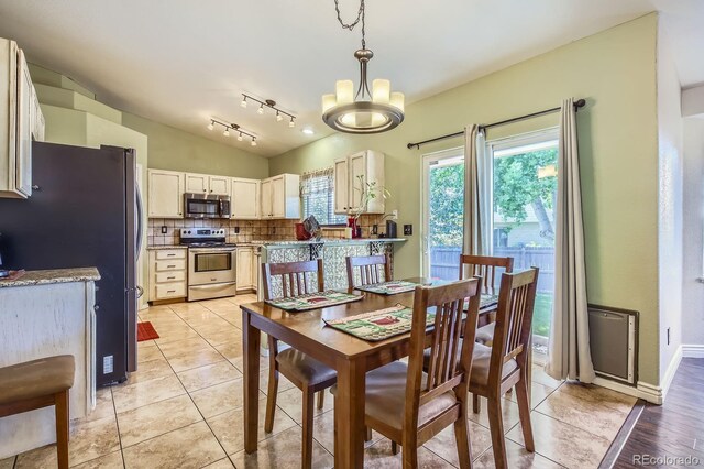 3143 50th Avenue Ct, Greeley, CO 80634 - dining space with a chandelier, lofted ceiling, and light tile patterned floors