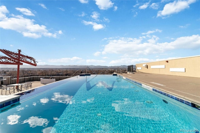 view of swimming pool with a mountain view and a patio area