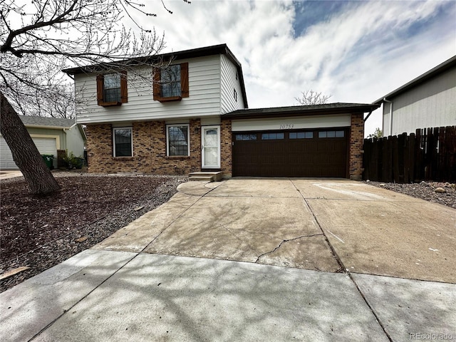10753 Routt Ct, Broomfield, CO 80021 - view of front facade with brick siding, an attached garage, concrete driveway, and fence