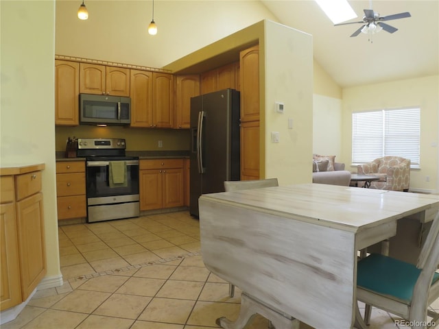 kitchen featuring light tile patterned flooring, a ceiling fan, high vaulted ceiling, and stainless steel appliances