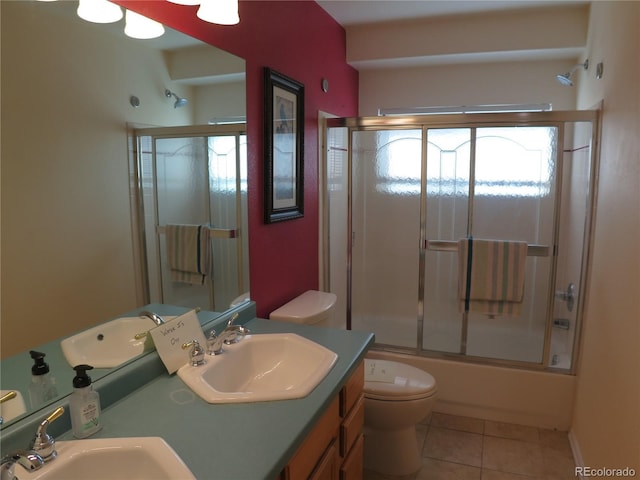 bathroom featuring vanity, enclosed tub / shower combo, toilet, and tile patterned flooring